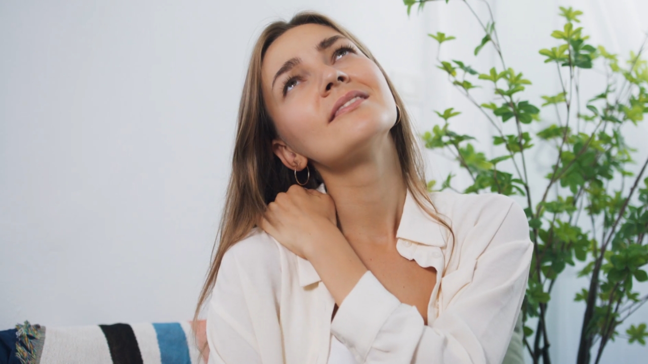 Žena drži ruku na vratu zbog bola i ukočenosti